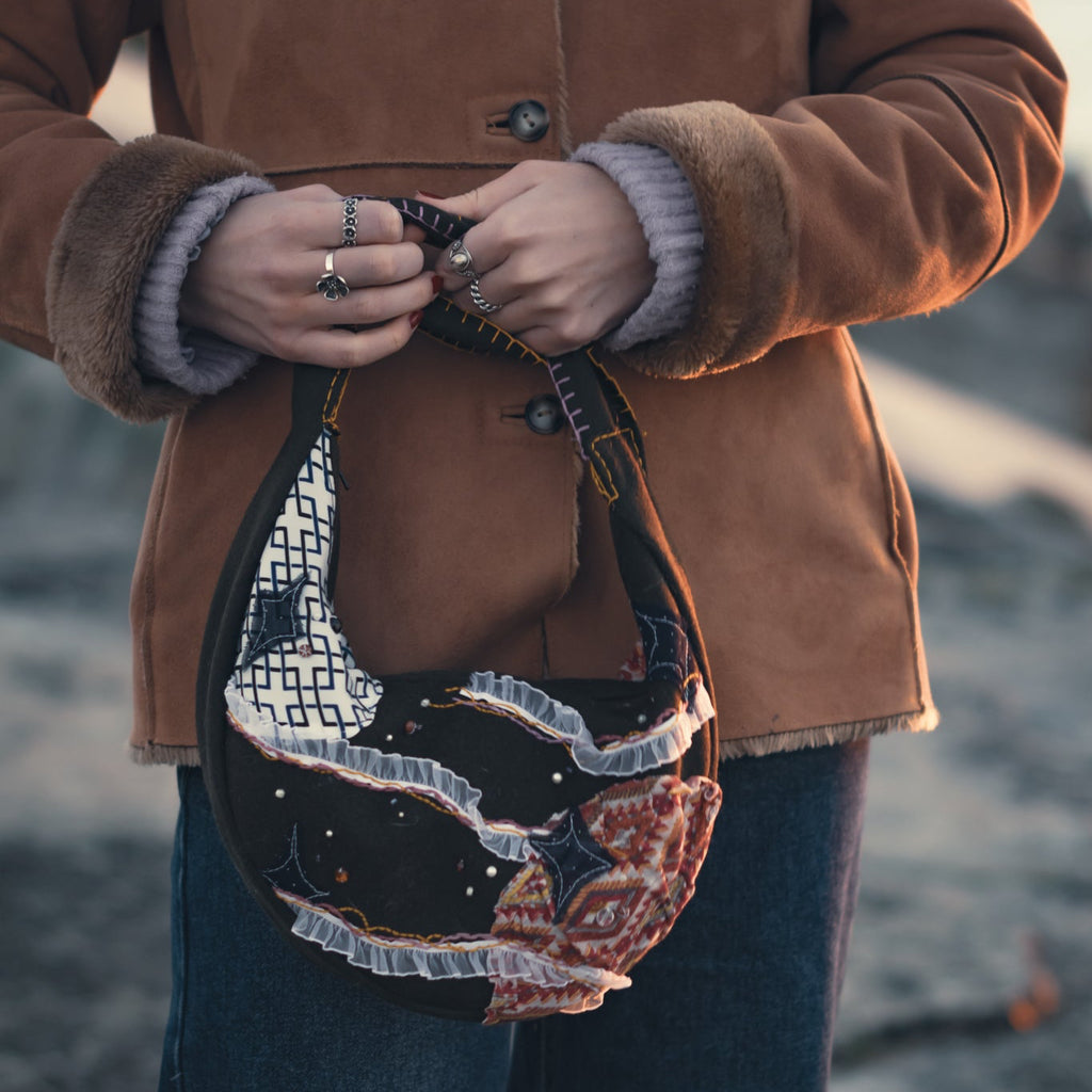 Close-up of sun and moon embroidery on handmade upcycled hobo bag, artisanal eco-friendly detail