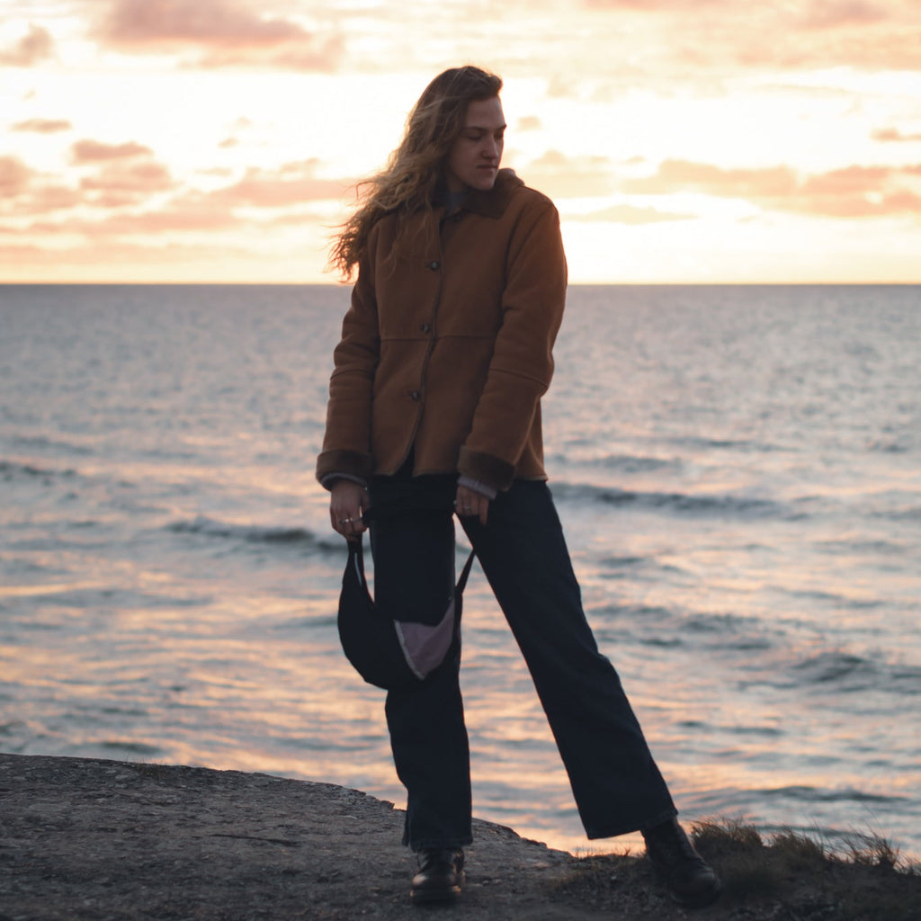 Eco-friendly upcycled hobo bag styled with casual outfit, sunset embroidery, sustainable statement handbag