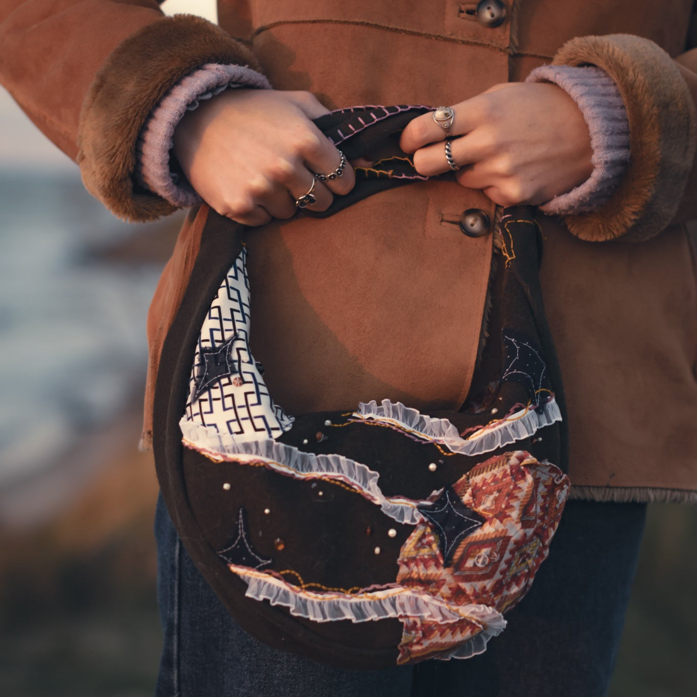 Eco-friendly upcycled hobo bag styled with casual outfit, sun and moon embroidery, sustainable statement handbag